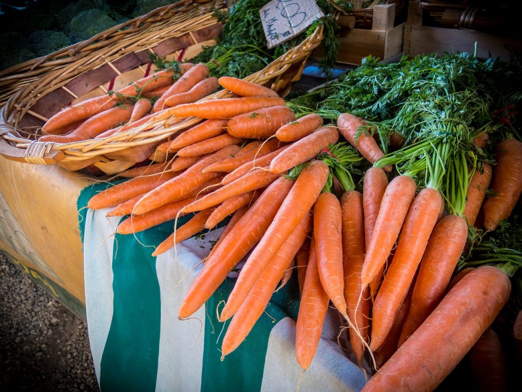 carrot-lot-73640 Vibrant fresh carrots on sale at a local farmers market, showcasing organic produce.